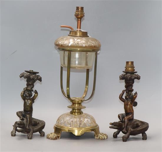 Two bronze putti candlesticks converted to lamps and a glass lamp
